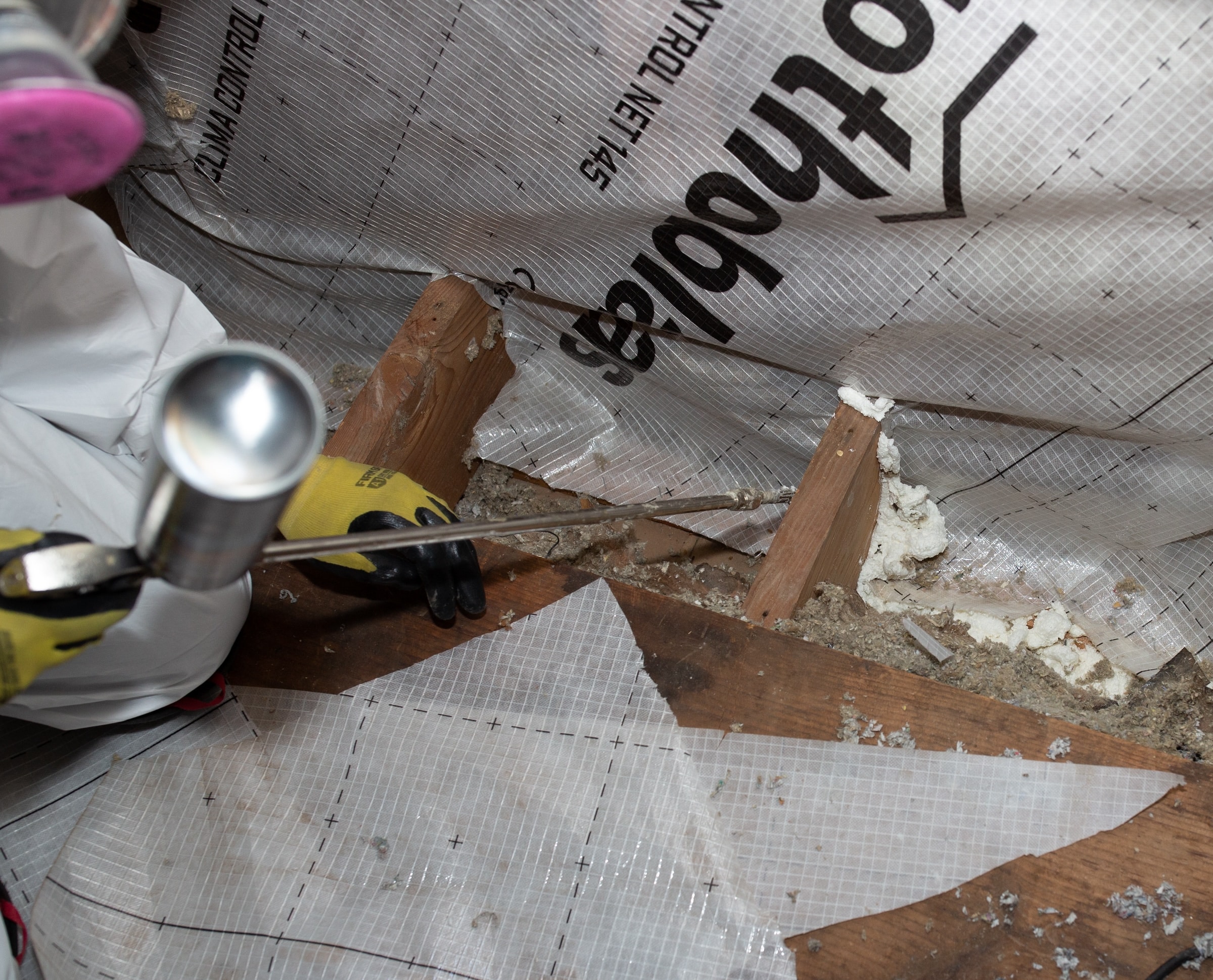Applying caulk in an attic