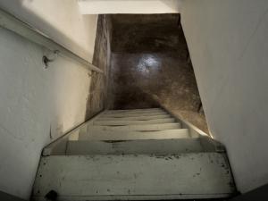 view down the stairs into an older unfinished basement