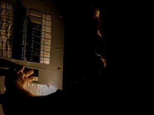 person checking breaker box of home in the dark during a power outage at home