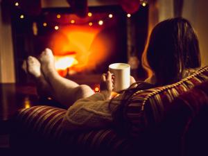 cozy woman at home in front of a fire