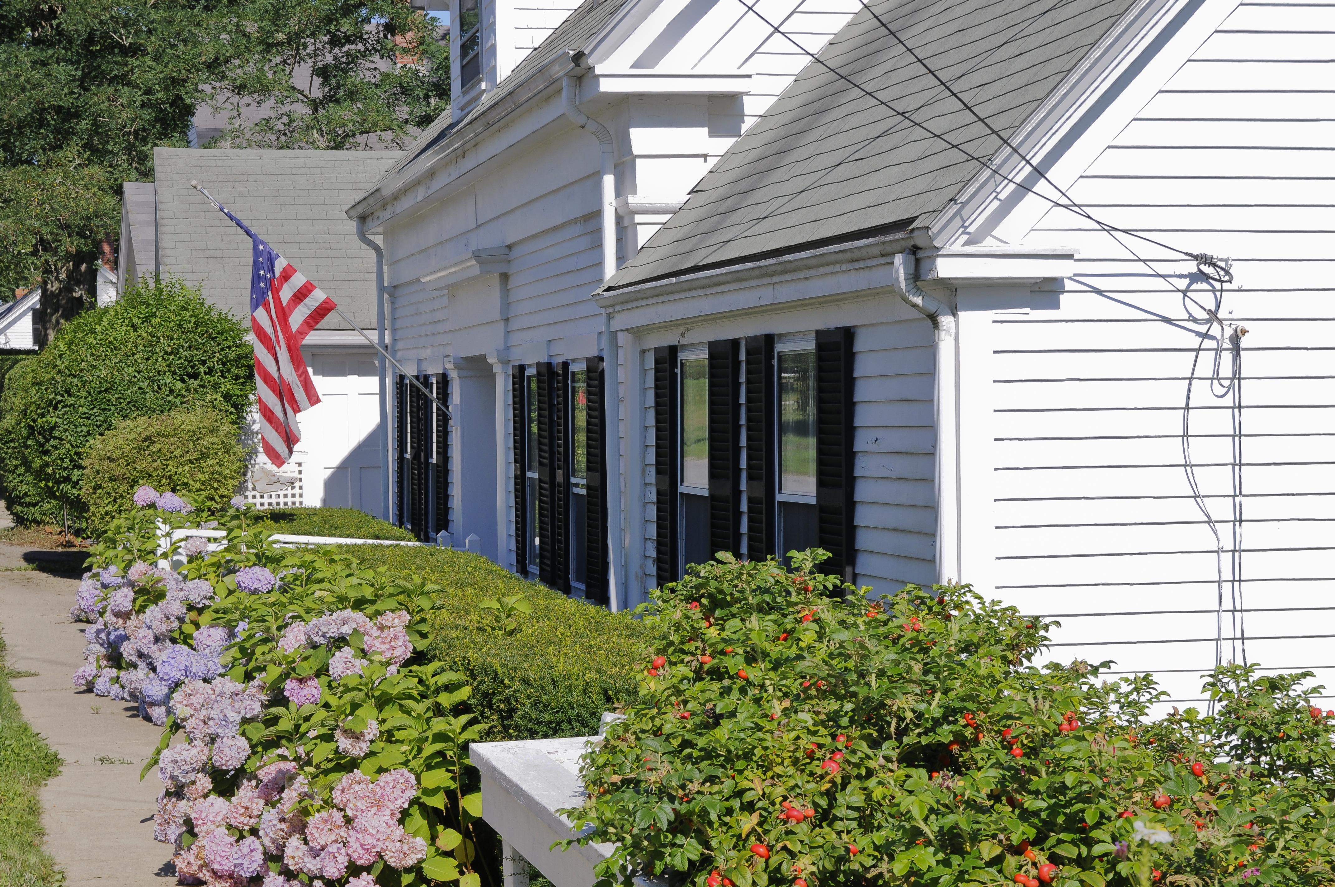 White home in maine with american flag outside