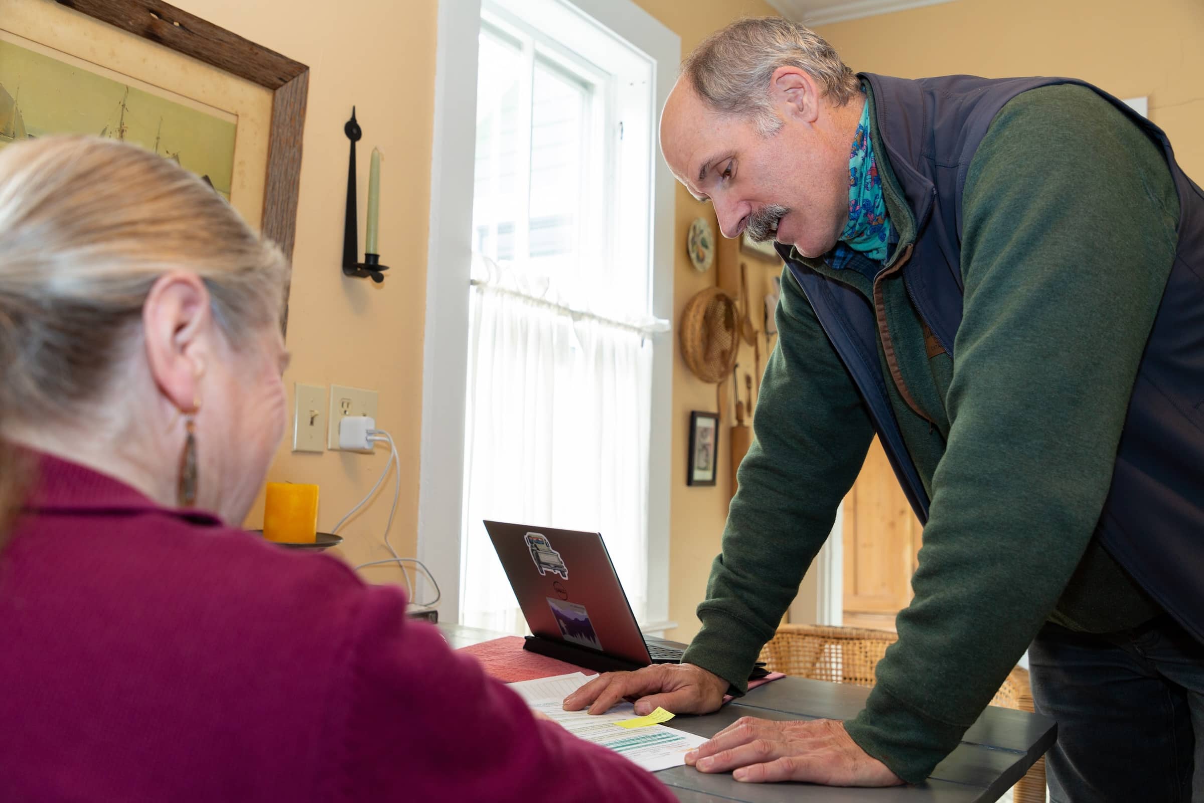 Evergreen Home Performance Team Working With Homeowner At Dining Room Table