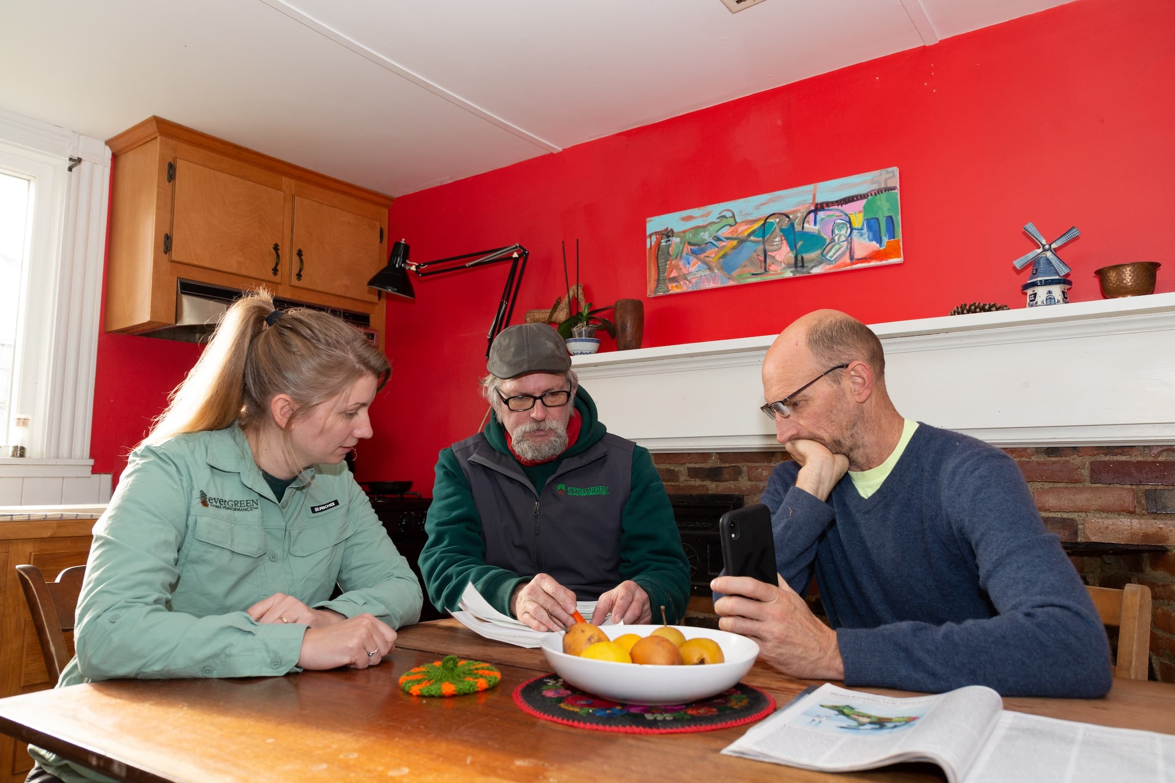 Evergreen team sitting around a table with a homeowner reviewing results from Energy Audit