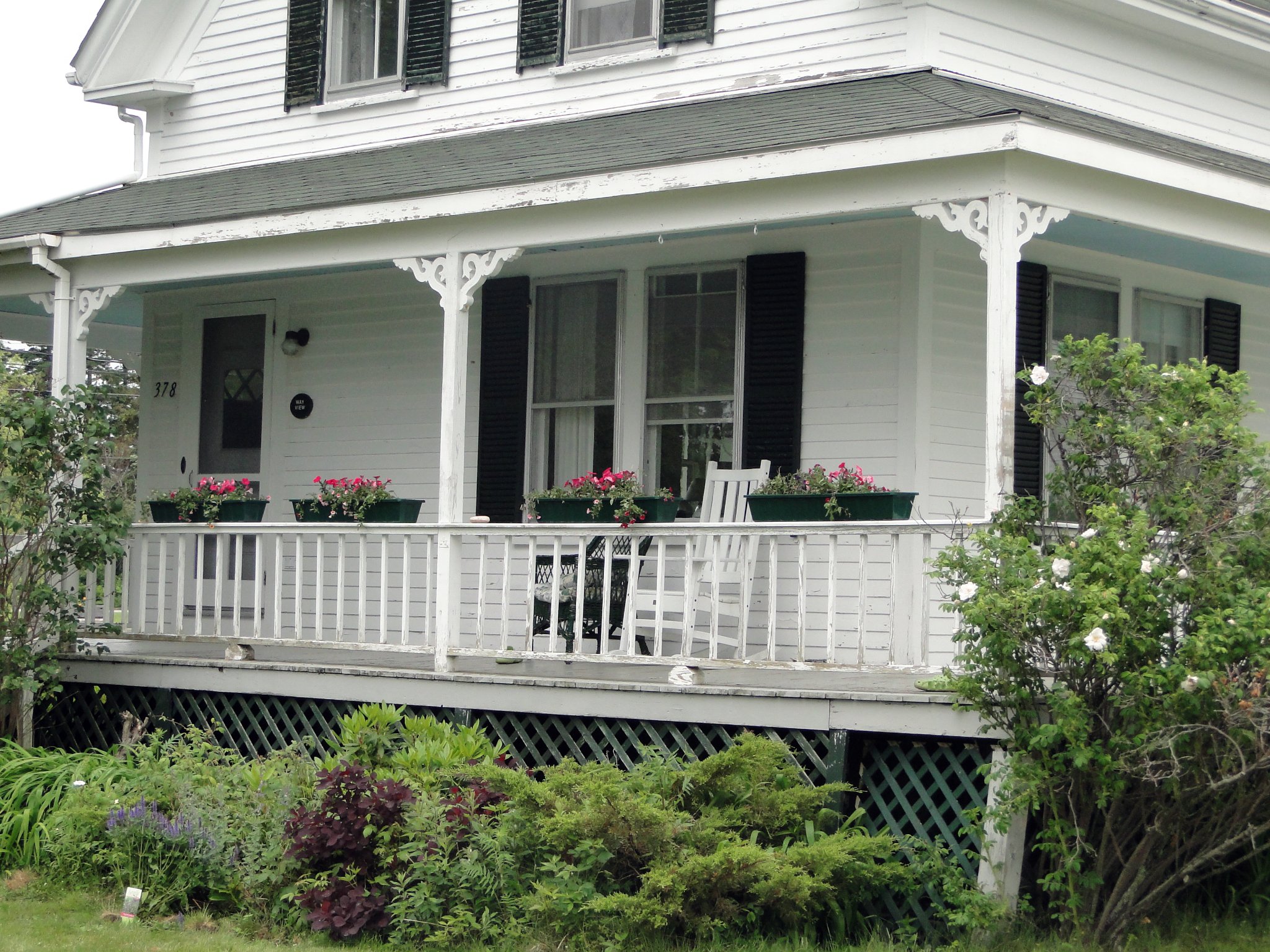 Old Cape House Porch With Beautiful Flowers And Greenery