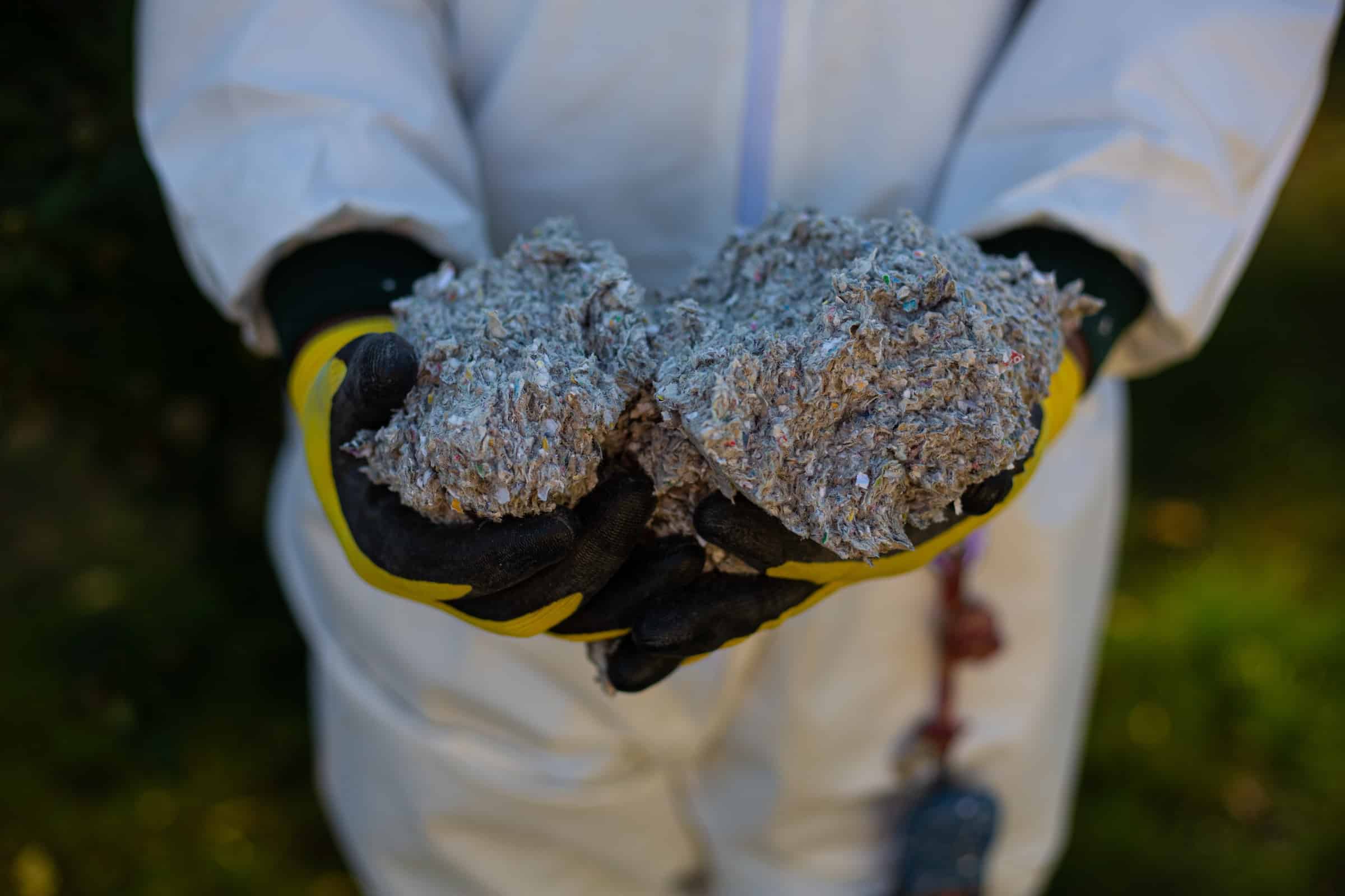 Blown Cellulose Insulation In Worker's Gloved Hands