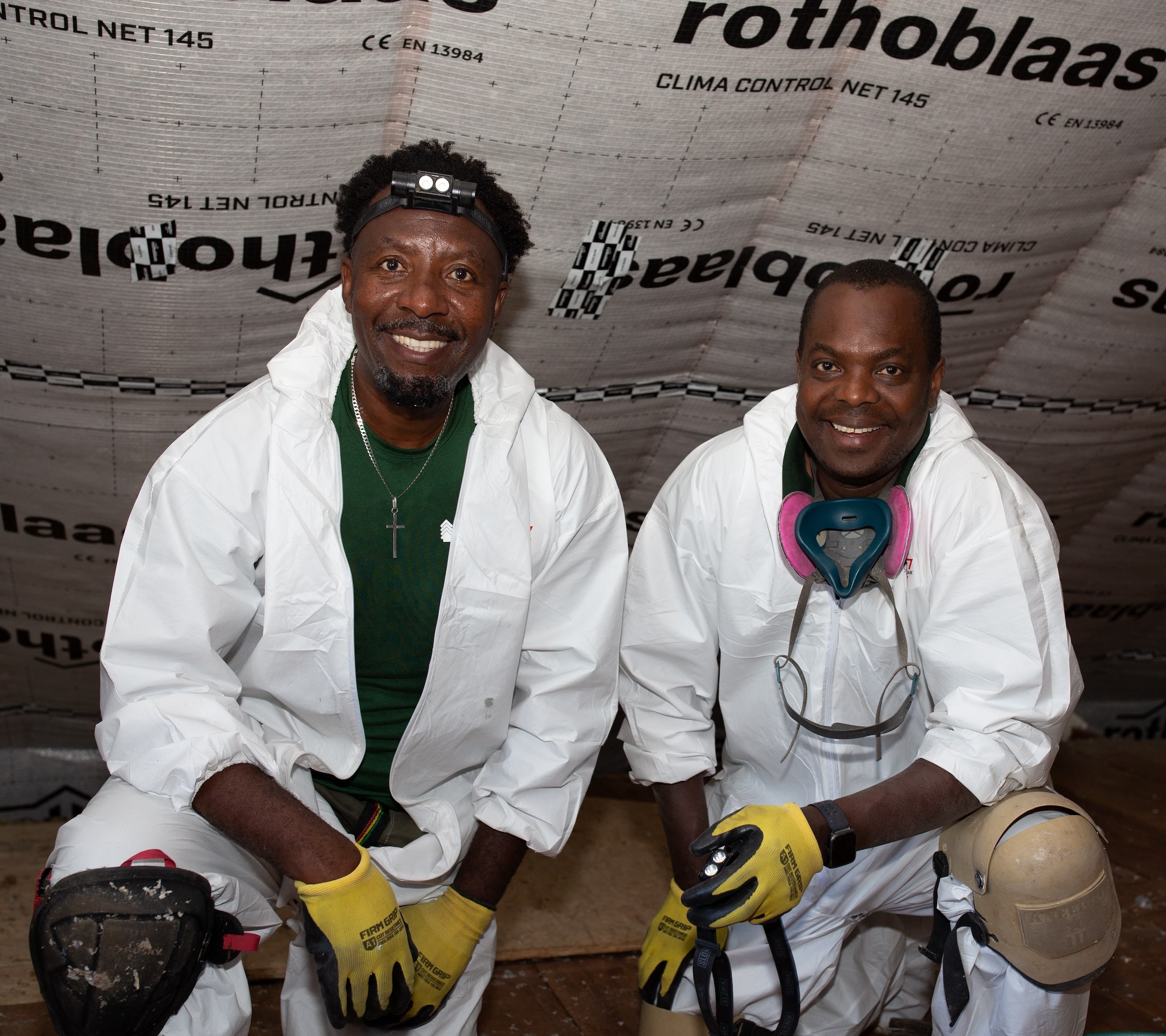 Evergreen Attic Insulation team members smiling in the attic during a job