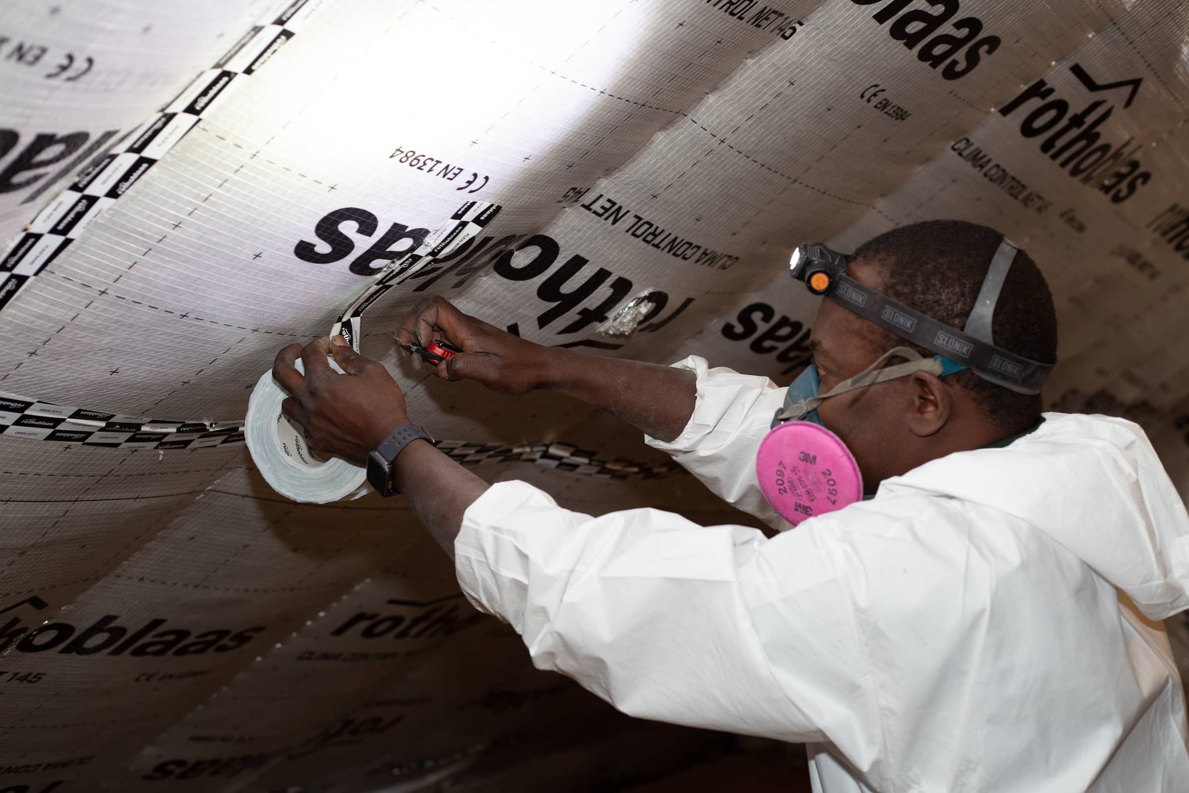 Evergreen team member adding climate control fabric during insulation job