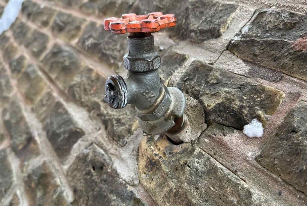 older spigot on the outside of a house