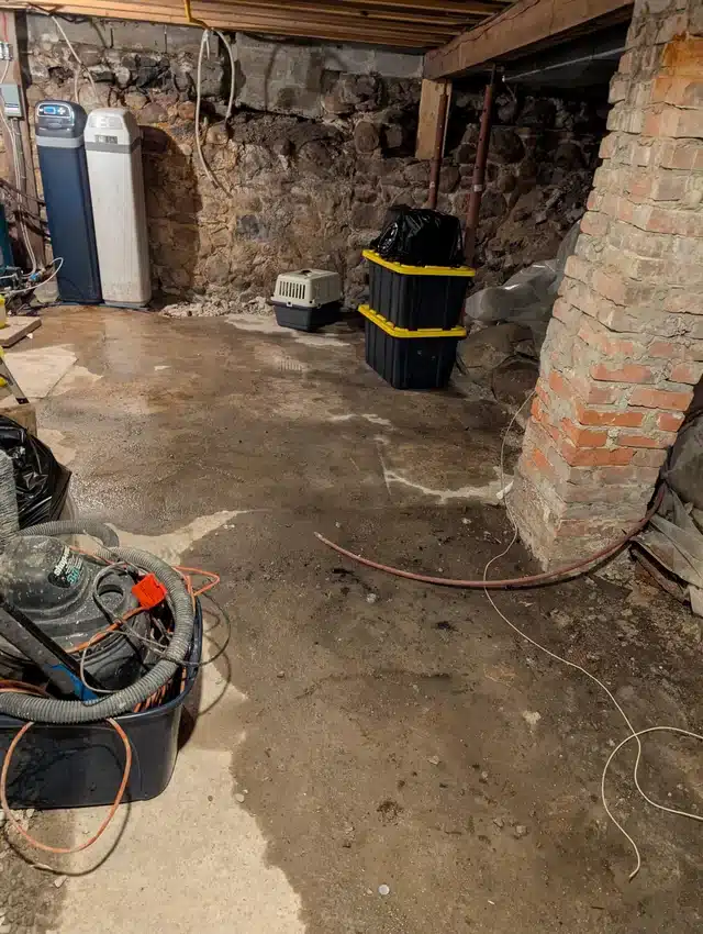 water-in-basement-after-heavy-rain-maine Standing water in basement after heavy rain with shop vac visible