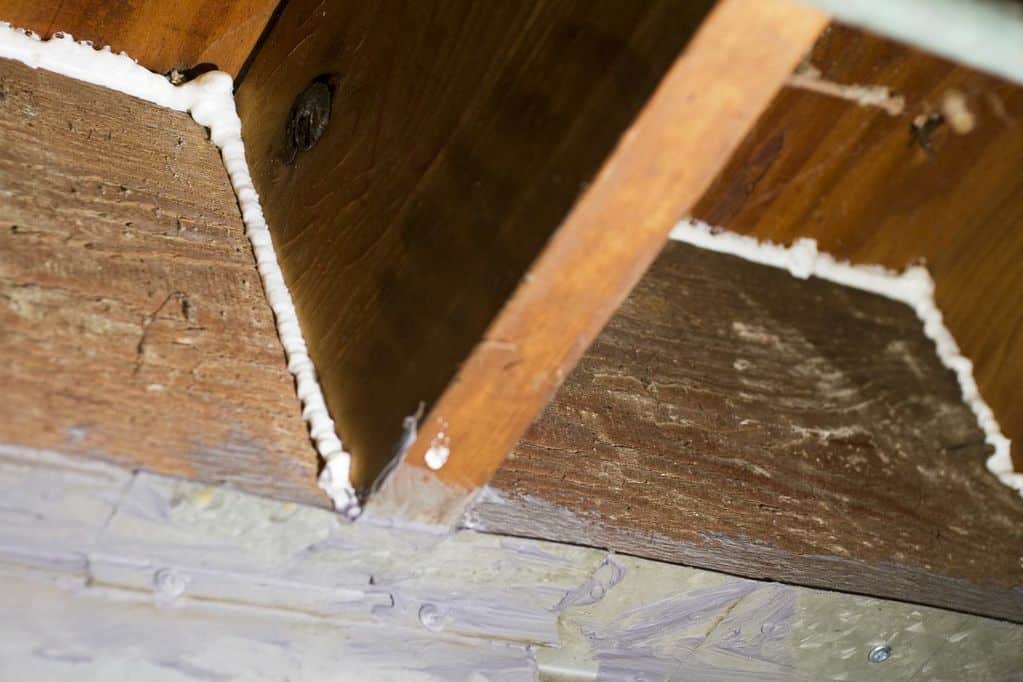 Closed-cell spray foam sealing joist bays at a rim joist